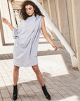 A woman wearing a grey knee-lenght shift dress by Malaika New York