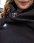 A close up of a woman wearing a black shift dress by Malaika New York
