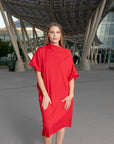 A woman wearing a beautiful off-the-shoulder knee-lenght shift dress by Malaika New York