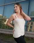 Side view of a woman wearing an off white sleeveless silk top