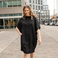 woman walking wearing a black shift dress by malaika new york