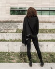 A woman wearing a black waterfall cardigan with a up-cycled biketube hem by Malaika New York