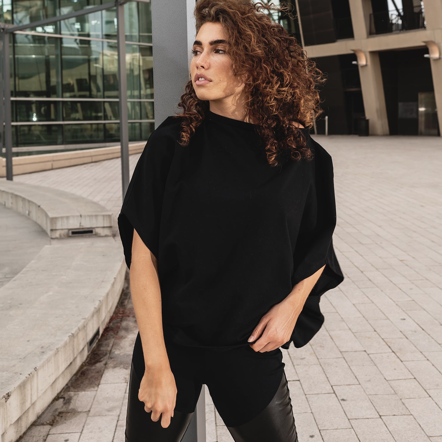 A model wearing Malaika New York organic cotton t-shirt. Shaped like a Hexagon making it versatile.