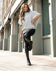 A woman standing on one leg wearing a grey organic cotton oversized t-shirt by Malaika New York