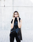 A woman wearing a asymmetrical black vest by Malaika New York