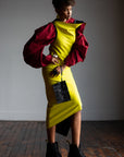 A black women wearing a red shirt and a yellow bodycon dress by Malaika New York