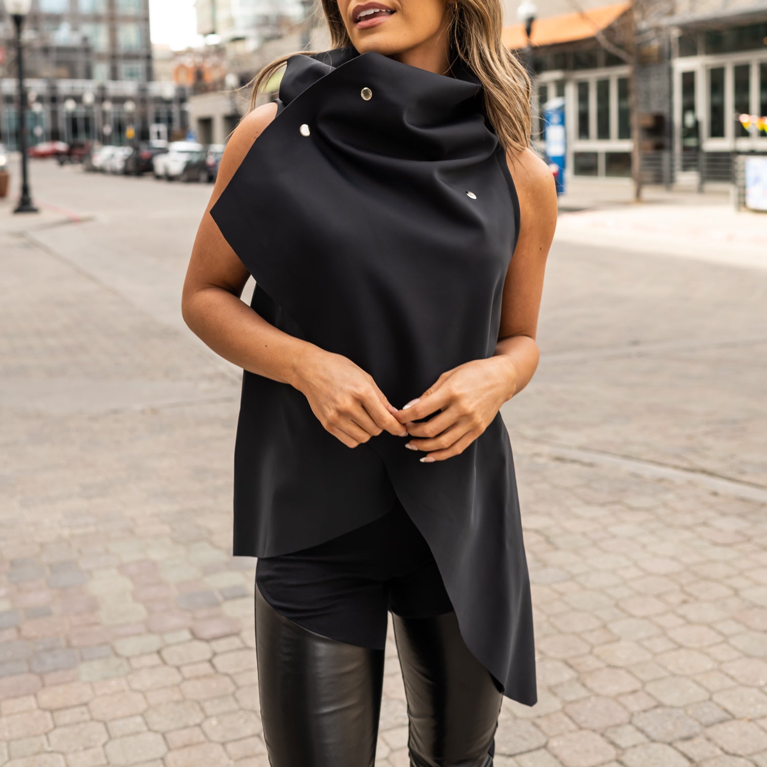 A woman wearing an asymmetrical vest in black by Malaika New York a zero waste vest design