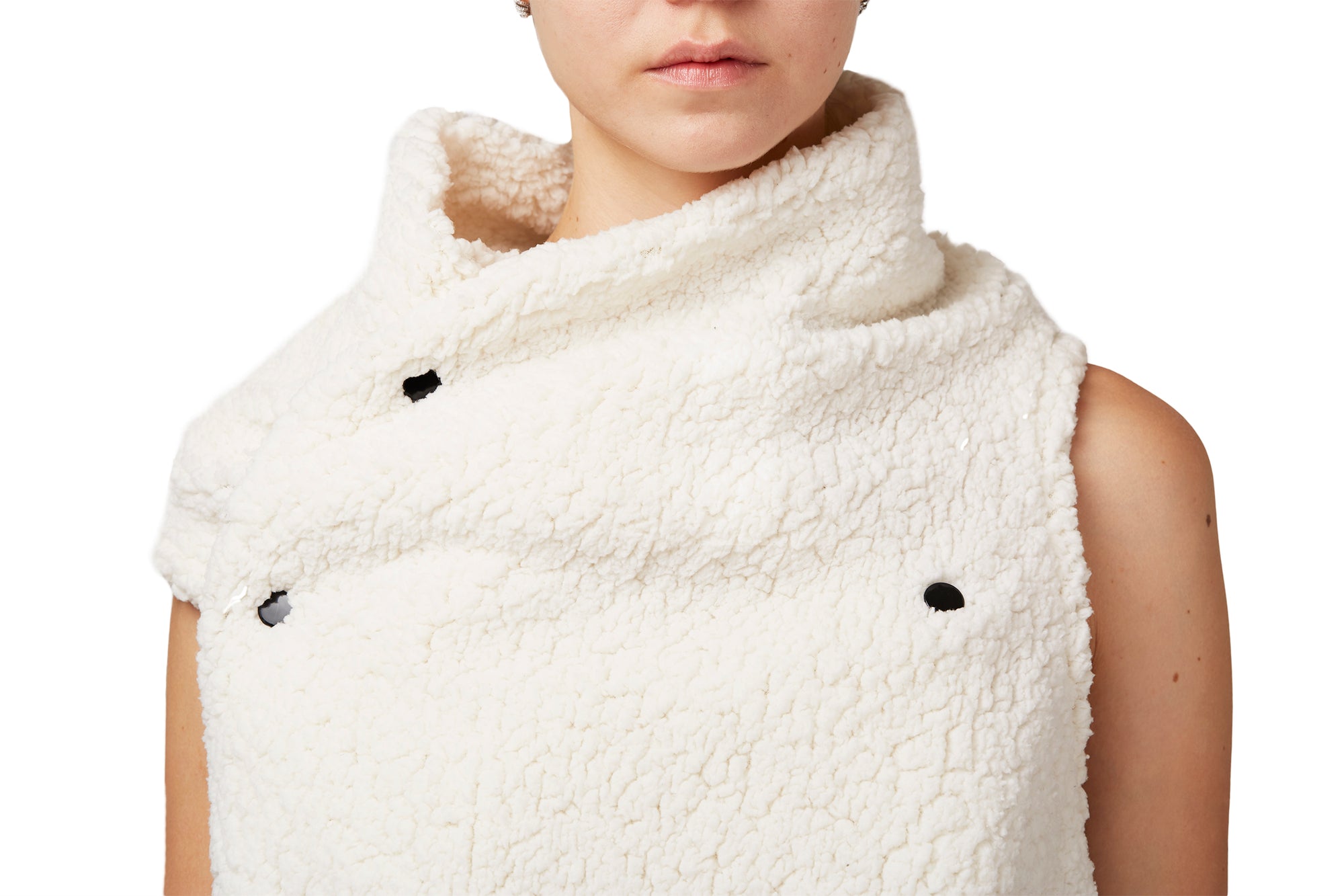 A woman wearing a white faux fur vest by Malaika New York