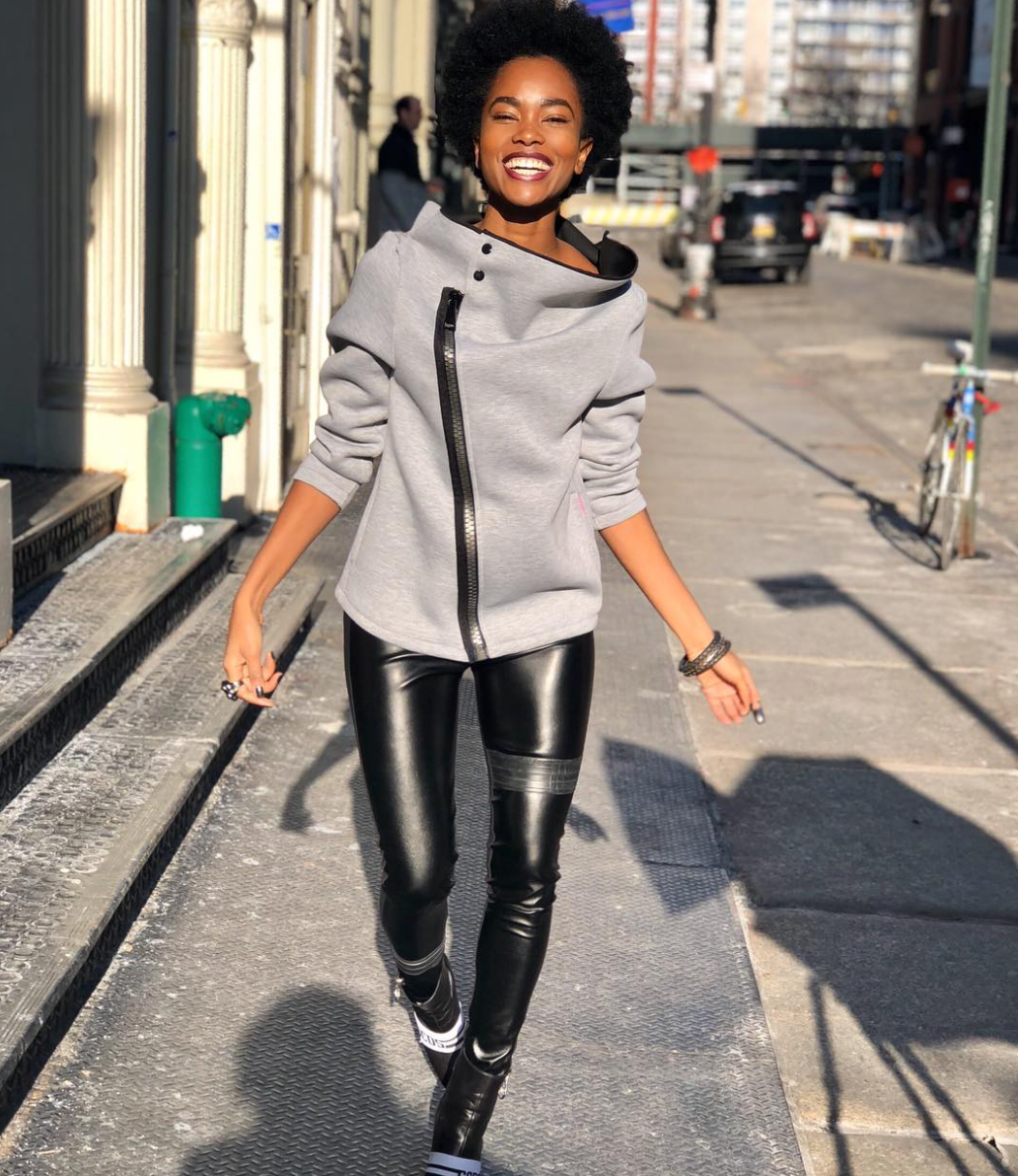 Model walking wearing faux leather leggings in New York