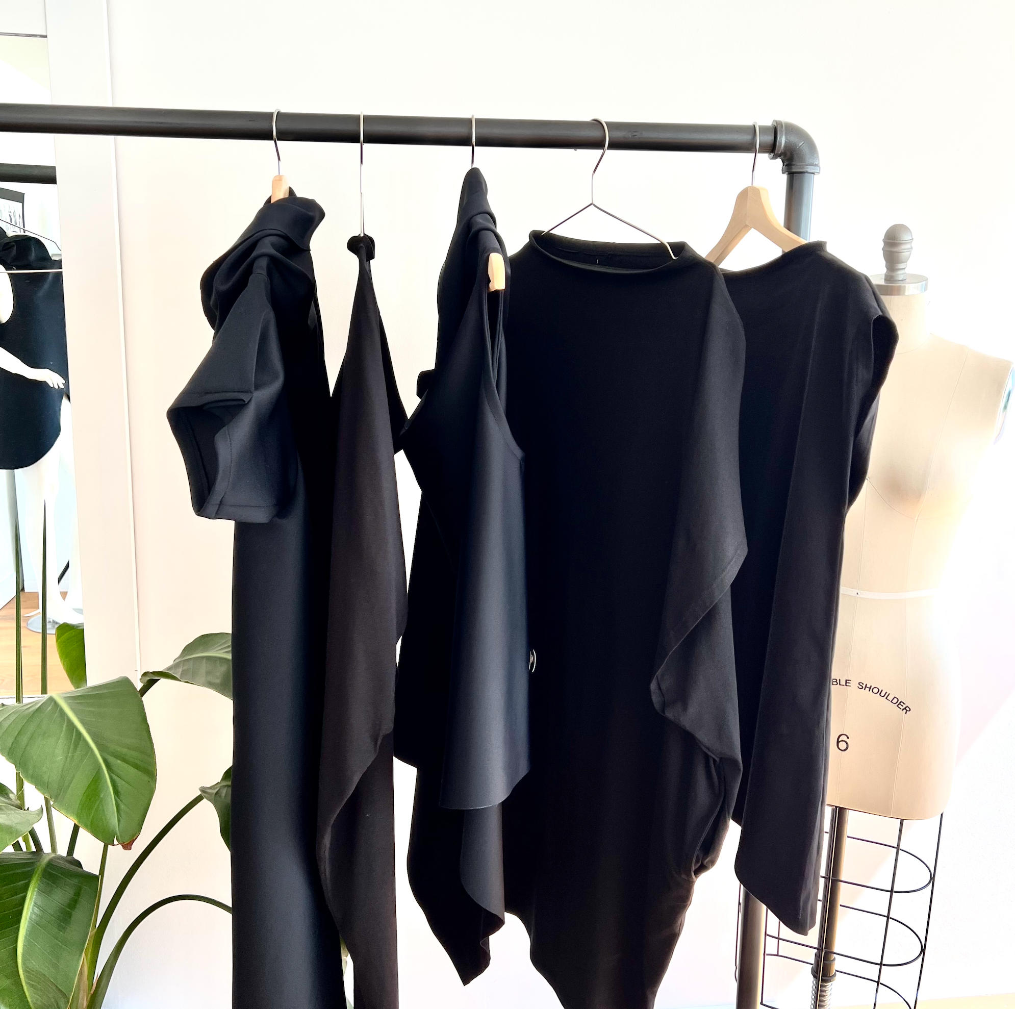 capsule collection of black shift dresses, asymmetrical tops and faux fur vest