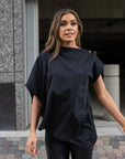 A woman wearing a black asymmetrical organic cotton t-shirt by Malaika New York