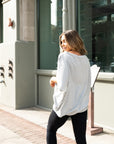 A woman with her back turned wearing an oversized grey t-shirt by Malaika New York