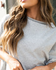 A close up of a woman wearing a grey organic cotton t-shirt by Malaika New York