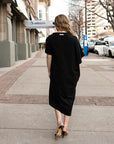 A back view of a beautifully draped dress by Malaika New York. A true black shift dress in organic cotton.