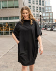 woman walking wearing a black shift dress by malaika new york