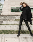 A woman wearing a black waterfall cardigan and faux leather leggings by Malaika New York