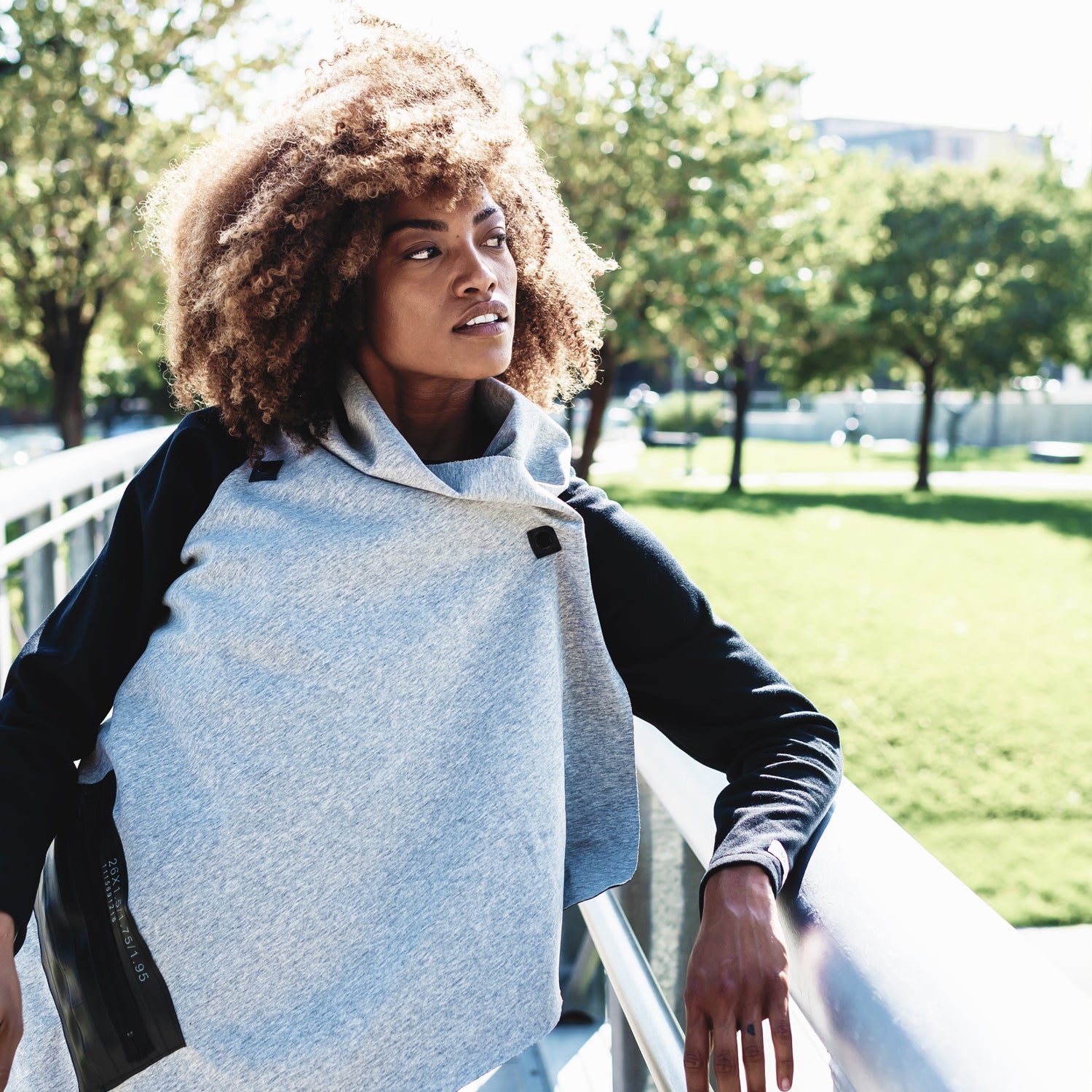 A woman wearing a color blocked grey cardigan in organic cotton with black sleeves by Malaika New York