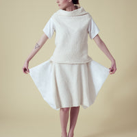 A woman wearing a vegan fur top and skirt by Malaika New York