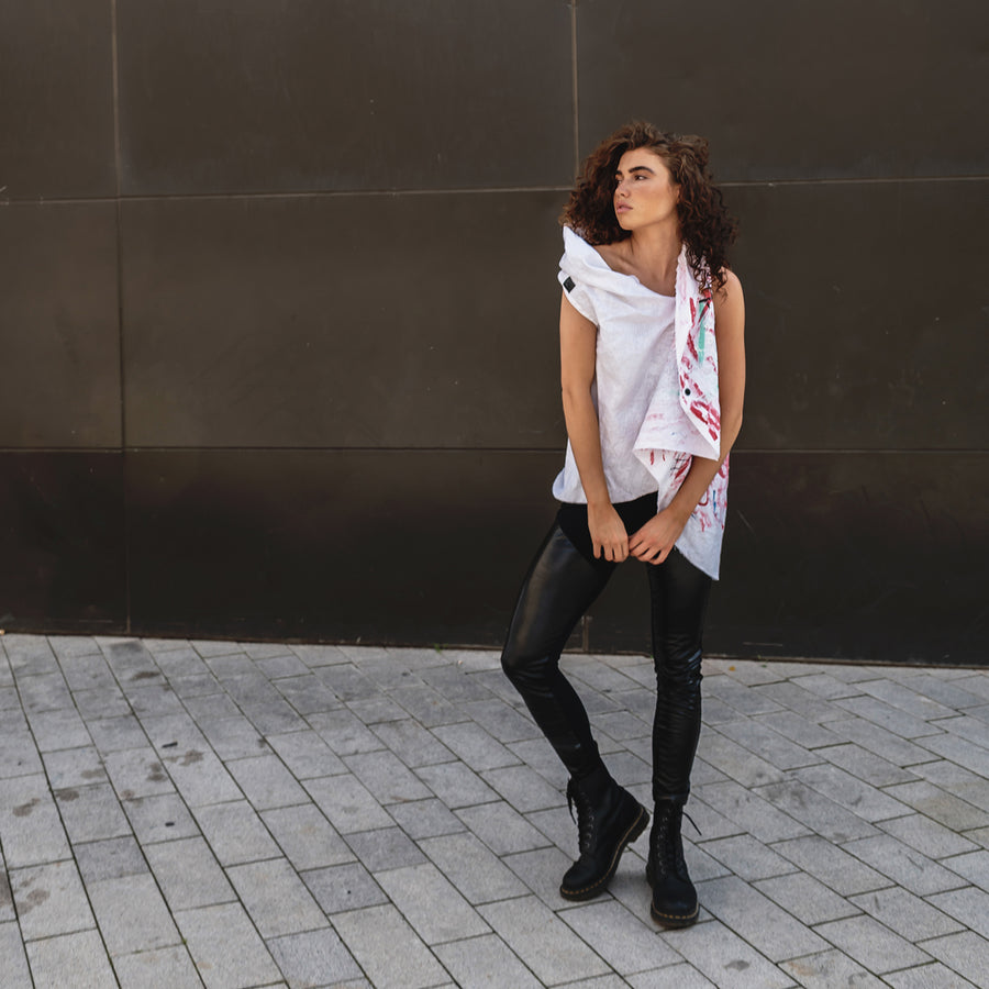 A woman wearing a linen vest and faux leather leggings a sustainable look by Malaika New York