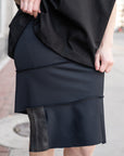A close of a woman wearing a black body con skirt by Malaika New York
