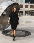 This is a photo of a women in our black hexagon t-shirt dress made from organic cotton. This shift dress is great for all body shapes.