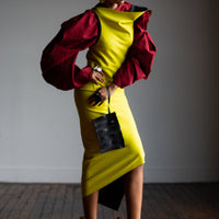 A black women wearing a red shirt and a yellow bodycon dress by Malaika New York