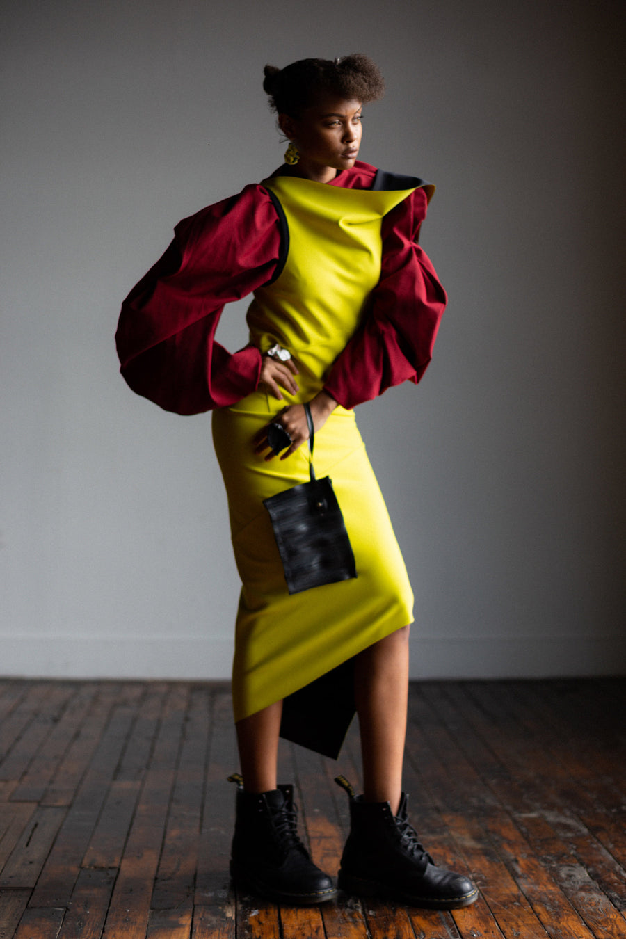 A black women wearing a red shirt and a yellow bodycon dress by Malaika New York