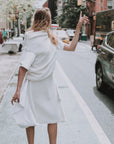 A model standing and getting a cab in Soho Manhattan in her vegan fur look by Malaika New York. A vegan fur skirt and vegan fur top.