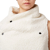 Close up of a woman wearing a white faux fur asymmetrical vest with black snaps by Malaika New York