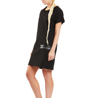A woman wearing a black organic cotton knee length dress